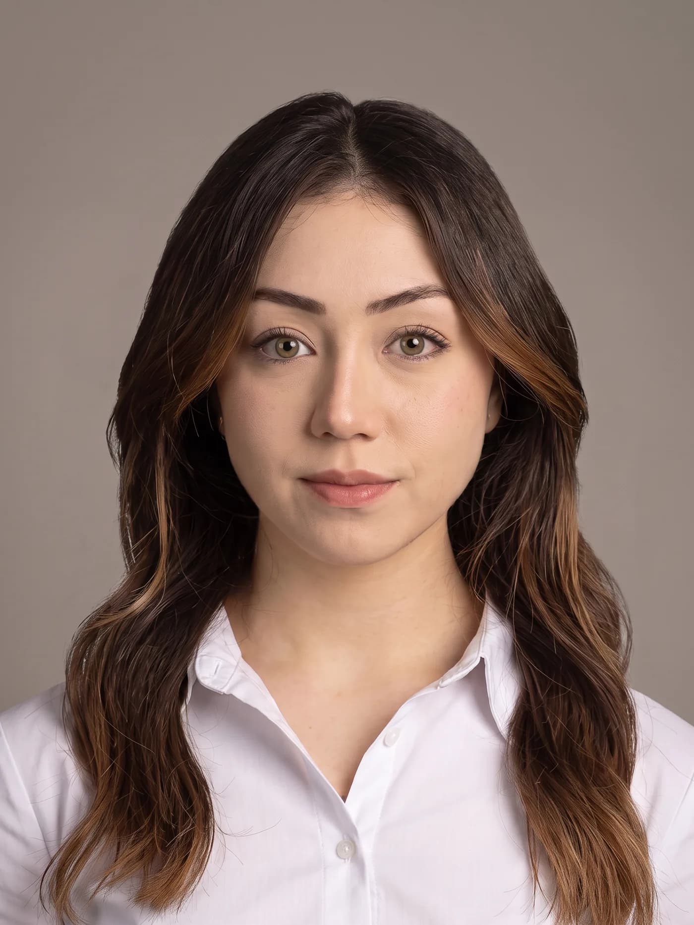 Rabia Şahin, beyaz gömlekle stüdyoda çekilmiş omuz hizası portre